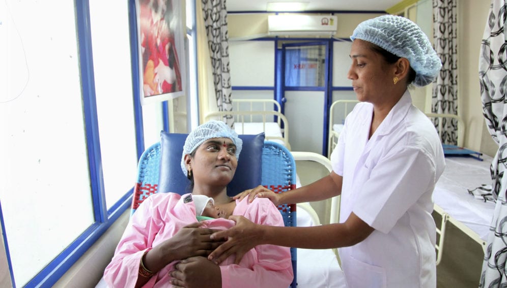 A member of the nuring staff with a mother and her premature baby