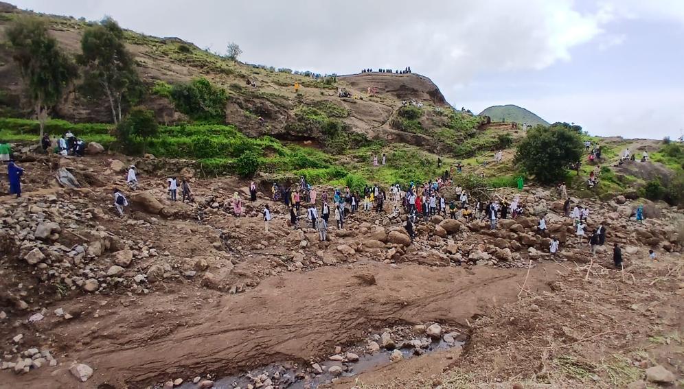 Survivors of a landslide in the village of Tarsin search among the rocks and rubble for other survivors and victims.