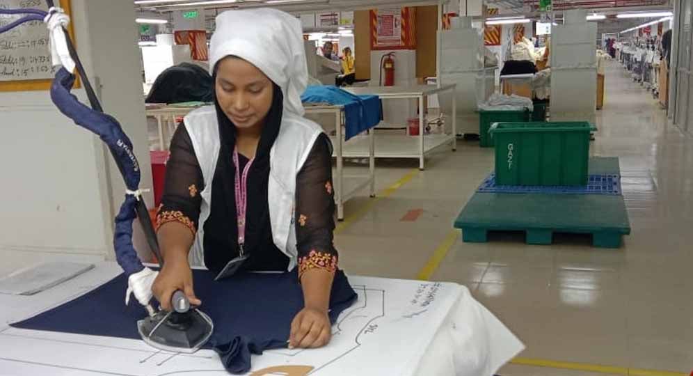 Fahima Akter Beauty ironing clothes that have just been stitched in a ready-made garment factory in Dhaka. Photo Credit: CARE Bangladesh (https://www.carebangladesh.org/)