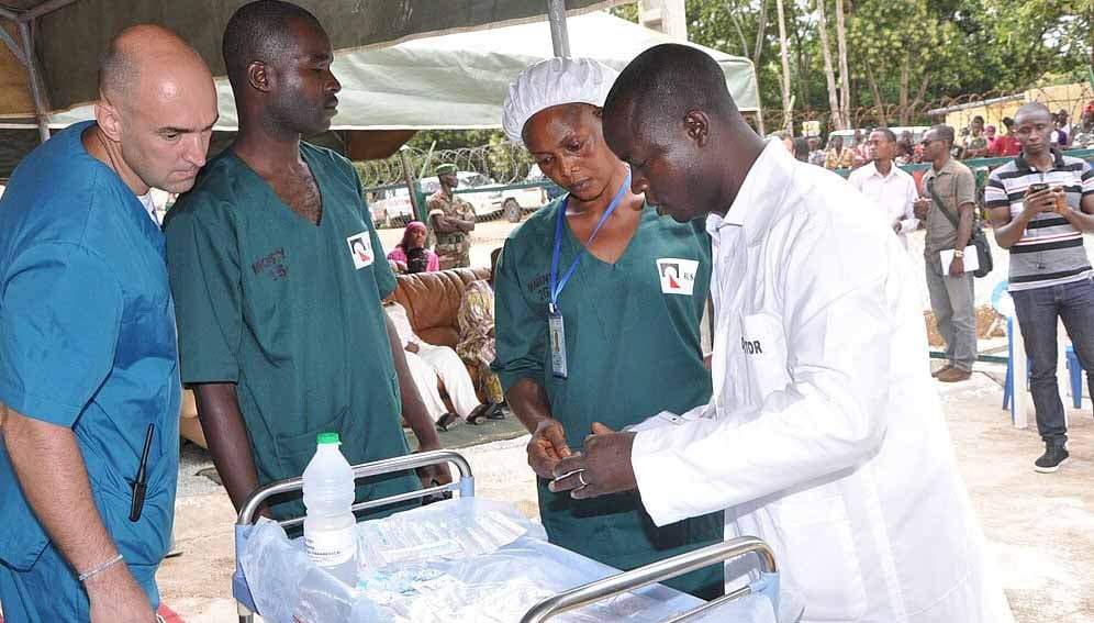 Health workers confer as part of the response to an Ebola outbreak.