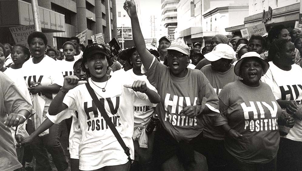 South African women wearing T-shirts that became an iconic symbol of the struggle for treatment access in the early 2000s. Deaths from HIV/AIDS and new infections could soar to levels unseen since the start of the century if planned funding cuts to foreign aid to foreign aid are sustained. Photo: Louis Reynolds