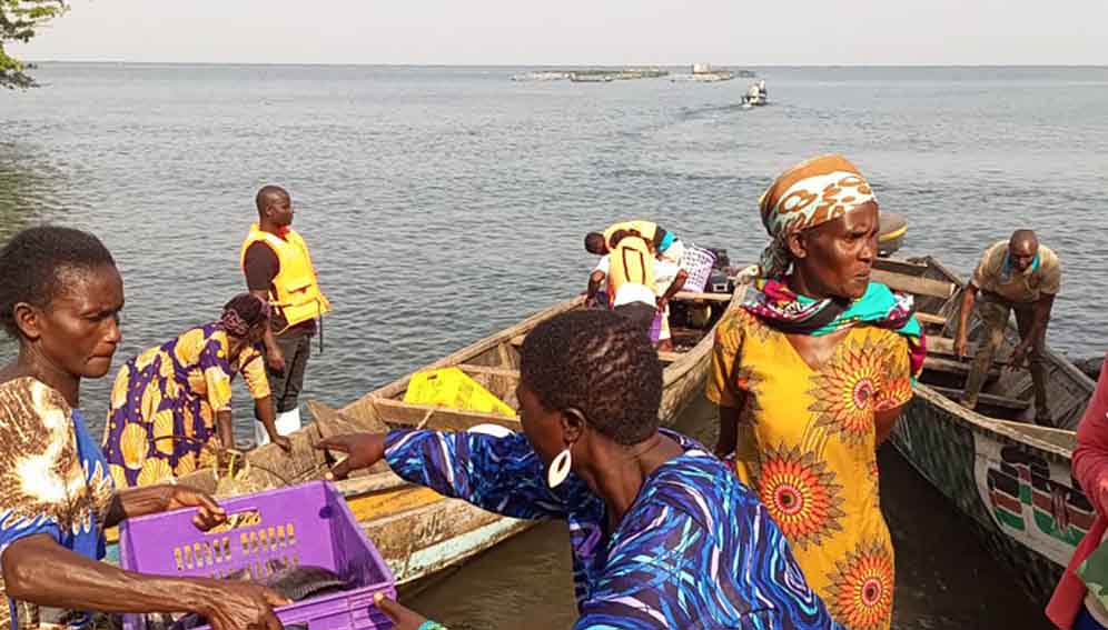 Women fish farmers delivering their harvest to waiting traders at Rasira beach.
