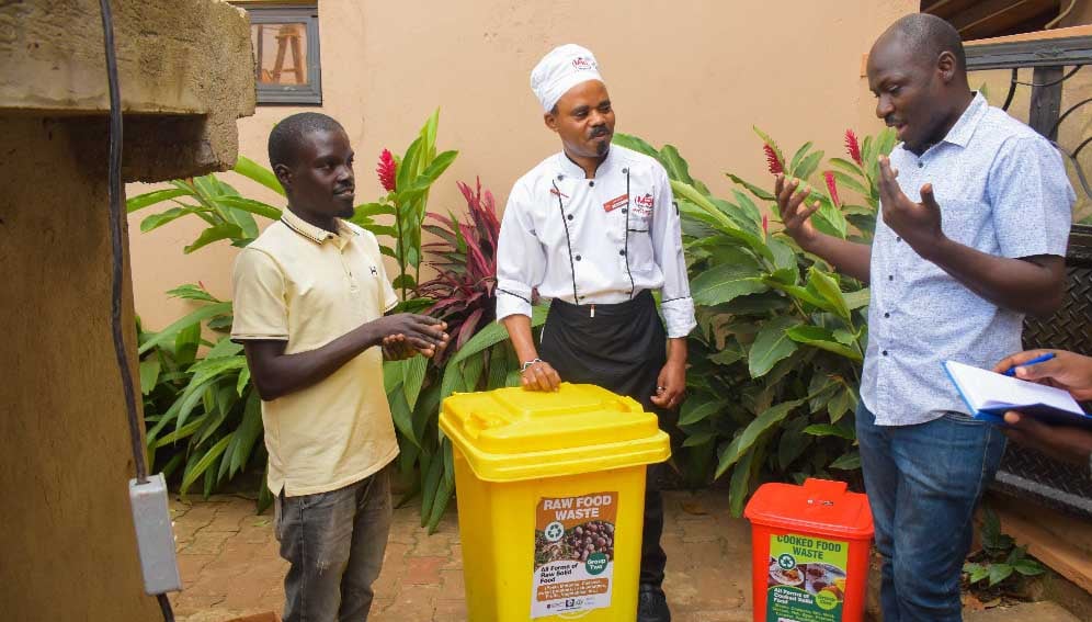 Lead researcher Geoffery Ssepuuya interracting with_one_of_the_raw food suppliers which he turns_ into cricket food 