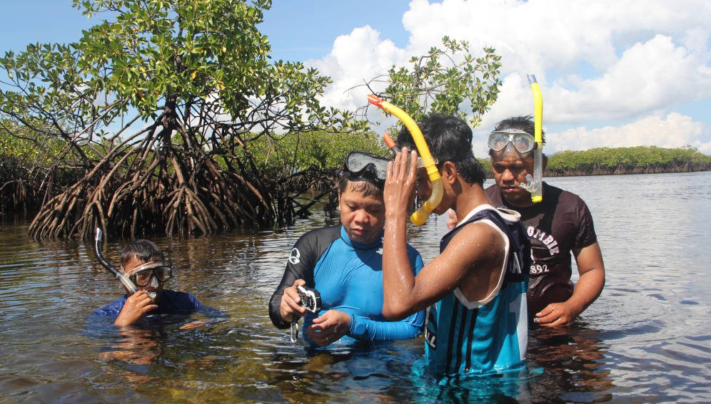 A fisheries scientist engaging with the community in Del Carmen mangrove forests in Siargao island. Photo Credit: NRCP