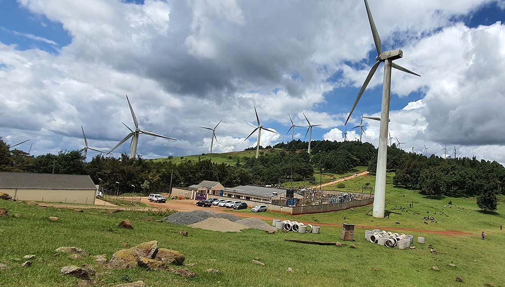 Some of the wind turbines and power station near the top of the Ngong Hills, Kenya. (Singularity Preparation: https://commons.wikimedia.org/wiki/File:Ngong_Hills_Wind_Farm.jpg)