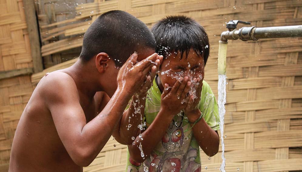 Children cooling off with clean, piped water in Khan Village, Lao PDR.